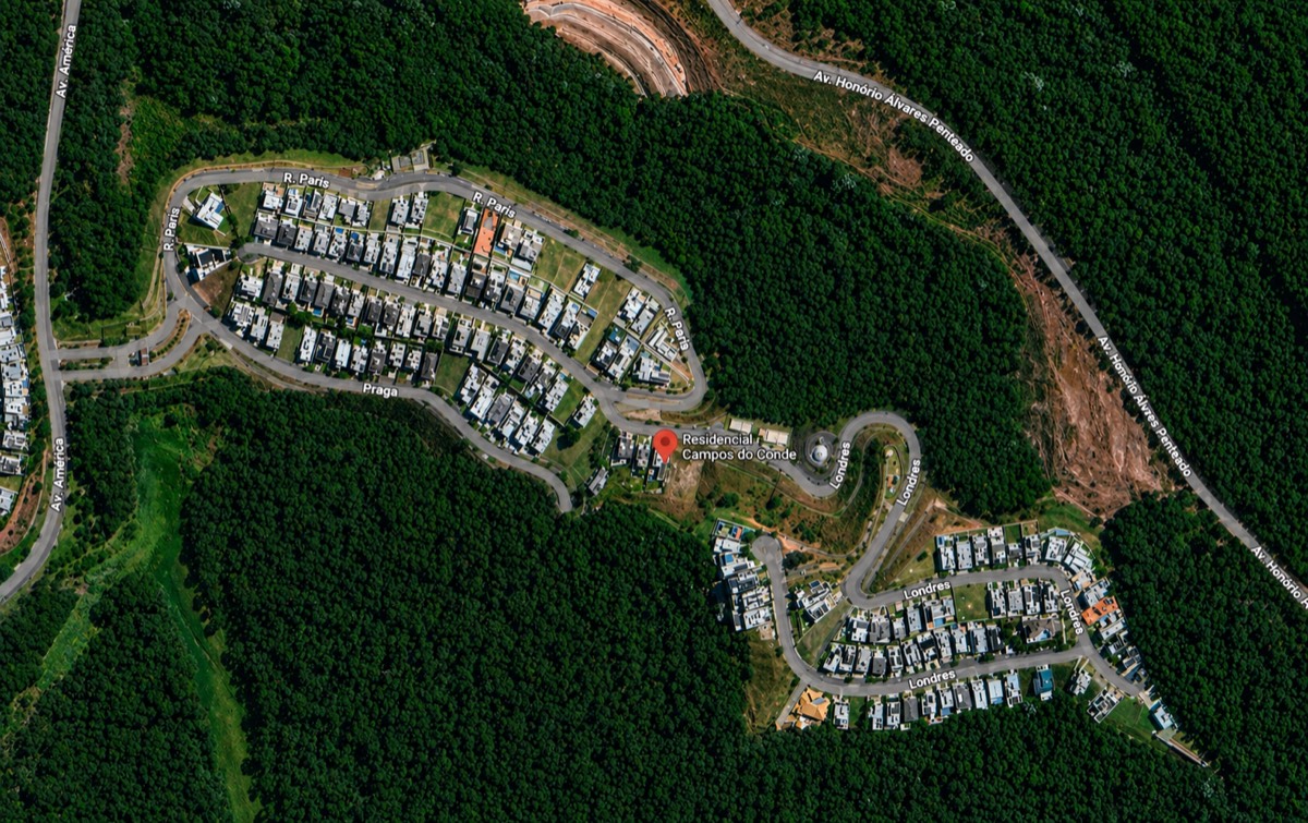 Vista aérea do Residencial Campos do Conde mostrando o traçado dos lotes em meio à mata preservada